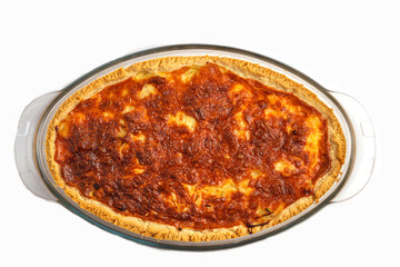 Traditional French onion pie, isolated on white.  Quiche lorraine with onion, cheese and eggs in a glass oven dish.