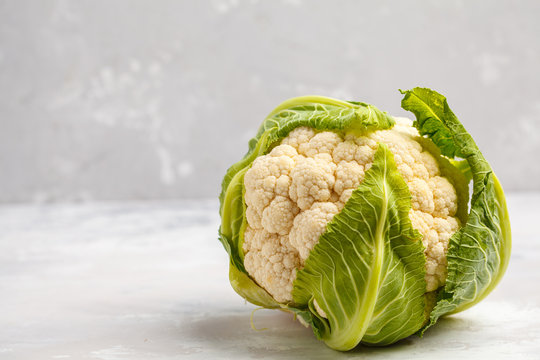 Ripe whole raw cauliflower on a light background on a napkin. Healthy vegan food concept.