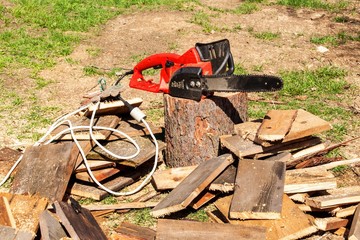Electric saws and chainsaw. Electric saw chain on the background of sawn timber. The concept of processing wood to produce fuel.