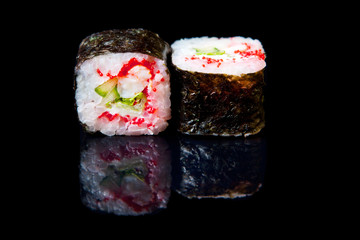 Traditional fresh japanese sushi rolls on a black background with reflection.