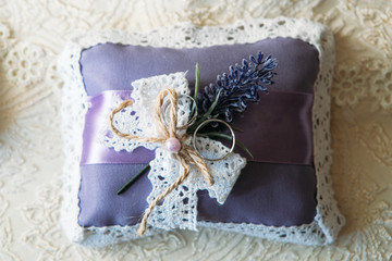 Wedding rings on a purple cushion