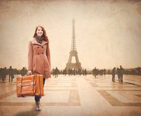 Naklejka na ściany i meble Redhead woman with suitcase come to Paris for conquer