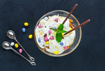 White chocolate ice cream and caramel dessert garnished with chocolate eggs and fresh mint