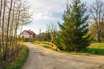 Rural dirt road, beautiful village in the summer, the road under the old fallen fence