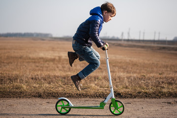 European boy riding and doing stunts on scooter