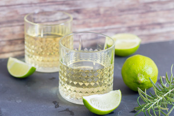 cocktail with limes on wood background