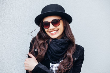 Smiling urban girl with smile on her face. Portrait of fashionable gir wearing a rock black style having fun outdoors