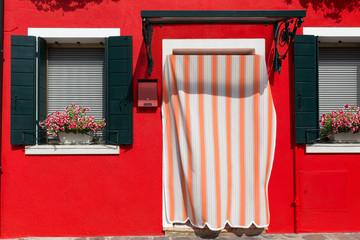 The facade of a yellow-painted house with beautiful Mediterranean-style shutters - obrazy, fototapety, plakaty