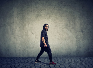 Trendy man in sportswear on gray