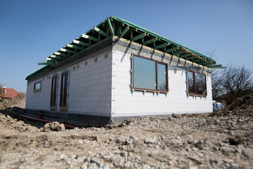 Rough construction of the modern house behind the fence