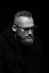 Obraz premium Male portrait close-up on a black background with glasses