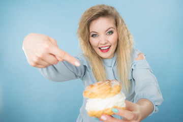 Funny woman holds cream puff cake