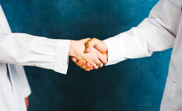 Two doctors shaking hands close up