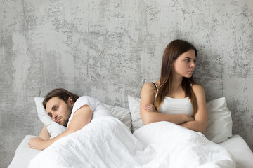 Sad millennial lovers after quarrel fight ignoring avoiding sex in bed, frustrated man and woman...