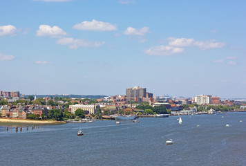 A panoramic view on Old Town Alexandria piers from the Potomac River, Virginia, USA. Waterfront of nationally designated historic district along the river on early morning.