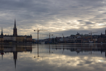 Fototapeta na wymiar The reflection of city of Stockholm, construction, cranes and old buildings