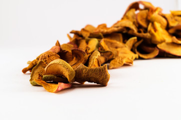 Dried apple slices stacked in loose form on a white background.