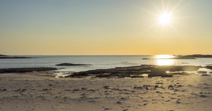 4k time lapse of the sun setting at the sandy beach of Sanna Bay of western Scotland with the camera moving sideways to the right