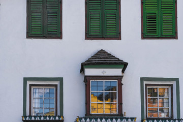 Holzkastenfenster mit grünen Fensterläden