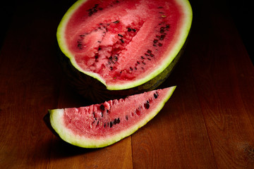 Fresh sliced and half of watermelon on wooden table