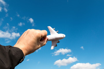 model of passenger airplane in hand on blue sky