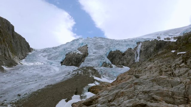 Glacier Buarbreen view with white clouds and blue sky line seamless endless timelapse near Odda Folgefonna National Park during summer hiking in Hordaland Norway Europe
