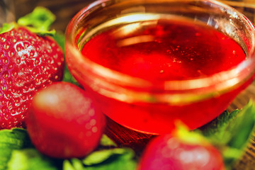 Fresh strawberries with leaves and jam close