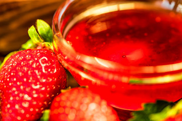 Fresh strawberries with leaves and jam close