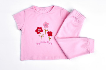 Set of beautiful clothes for baby-girl. Pink cartoon t-shirt and leggings for infant girls, white background.