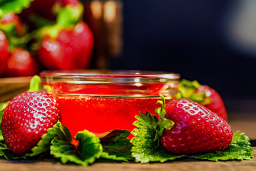 Fresh strawberries with leaves and jam close