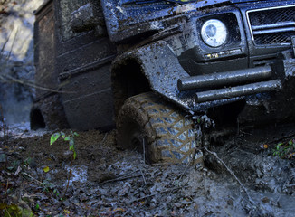 Wheel in deep rut goes through mud and leaves trail.