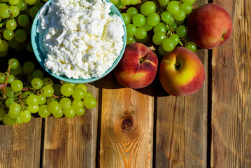 Plate of homemade cottage cheese, grapes and peach on wooden rustic table.Copy space for text.