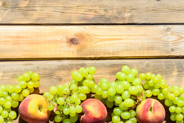 First fruits habikkurim in hebrew on wooden rustic table. Symbols of jewish holiday - Shavuot. Grapes and peaches on wood vintage background.