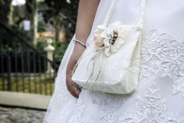 Niña vestida con accesorios y bolso de primera Comunión