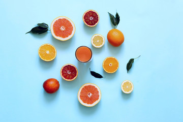 Fresh juices and fruit cut into slices on a turquoise background