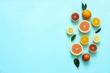 Fresh citrus fruits split on turquoise background.