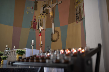 Altarbereich mit Opferkerzen in einer katholischen Kirche