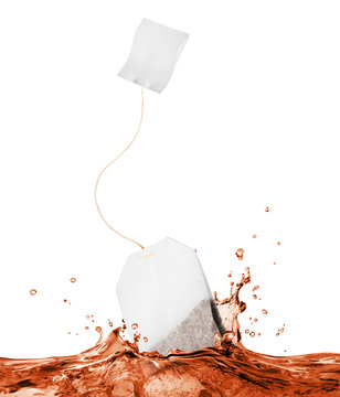 Tea Bag Falls Into Splashes Of Tea On White Background