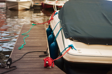 a modern motor boat windshield and bow deck covered in a blue canvas rain cover, with a weathered...