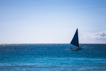 One double outrigger sailboat on the sea