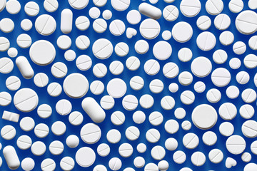 White medicine pills on a blue background