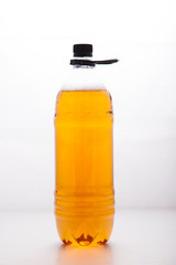 Plastic disposable transparent bottle with a light beer on a clean white background