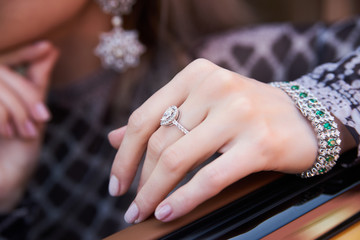 Beautiful woman with yellow sport car. Young female model with lixury diamonds jewerly sitting in a expensive car