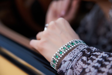 Beautiful woman with yellow sport car. Young female model with lixury diamonds jewerly sitting in a expensive car