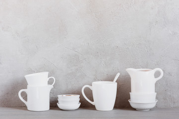 White crockery on the table against the textured grey wall