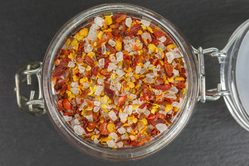 sea salt mixed with dried chili flakes and seeds in a glass jar