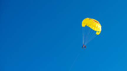 yellow parachute flight. A parachute with a smile. Rest on the water. Journey through the sky. Active time at the resort. Beach entertainment.