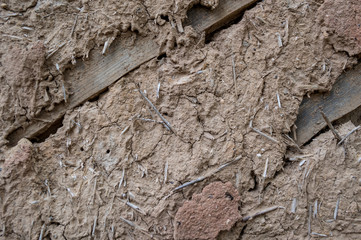 Cracked wall surface of the old wattle and daub house. - obrazy, fototapety, plakaty