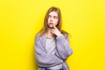 Offended teenager girl isolated over yellow