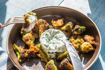 Fried broccoli in batter with spicy white sauce